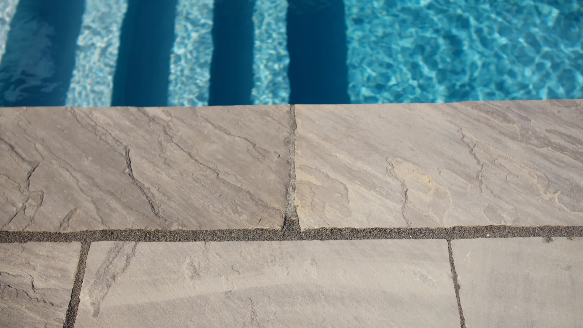 Detalje af poolkant og flisebelægning