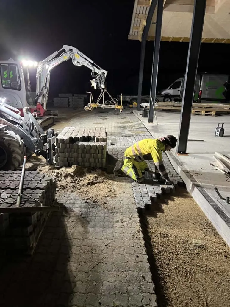Maskinebelægning lægges med belægningsmaskine ved industriprojekt