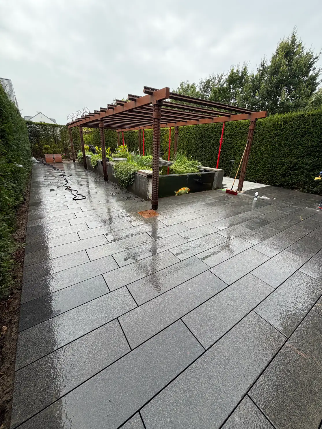 Granitterrasse med pergola og fiskedam