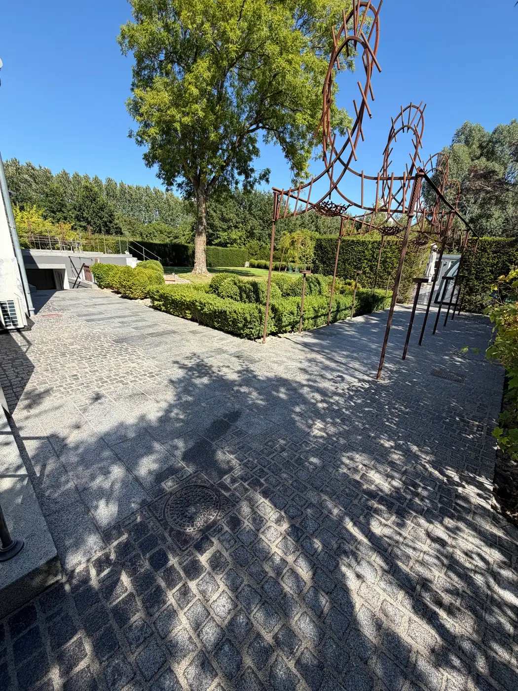 Granitbelagt gårdsplads med pergola